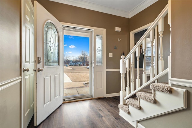 foyer with stairs, crown molding, wood finished floors, and baseboards