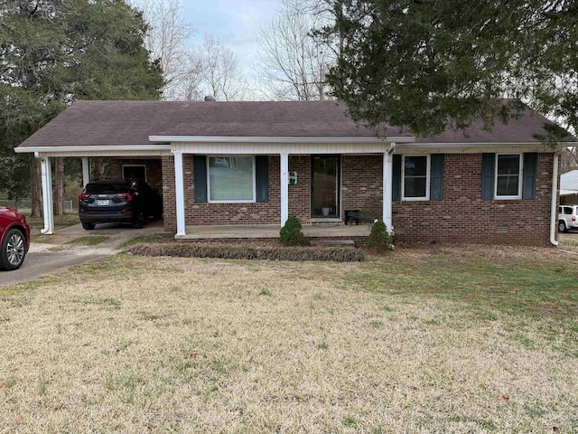 single story home with an attached carport, roof with shingles, a front lawn, aphalt driveway, and brick siding