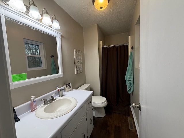 bathroom with vanity, wood finished floors, a textured ceiling, curtained shower, and toilet