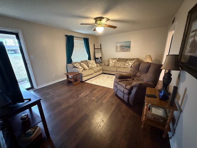 living area with baseboards, ceiling fan, and wood finished floors