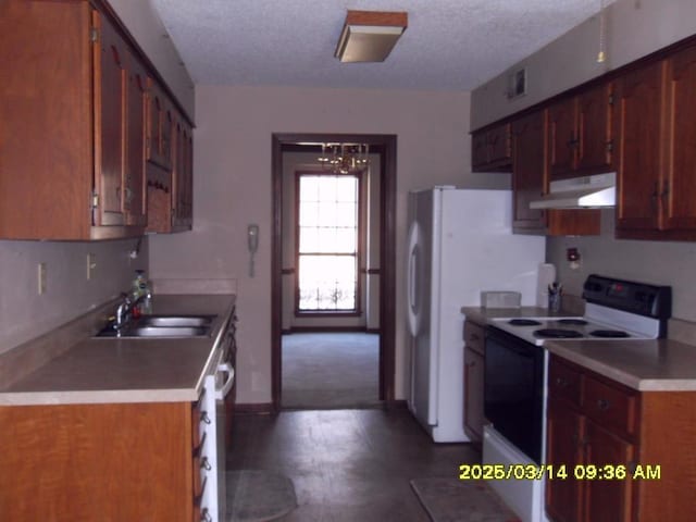 kitchen with under cabinet range hood, a sink, a textured ceiling, white appliances, and a chandelier