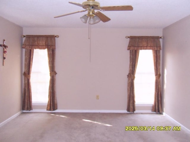 unfurnished room with baseboards, a healthy amount of sunlight, and ceiling fan