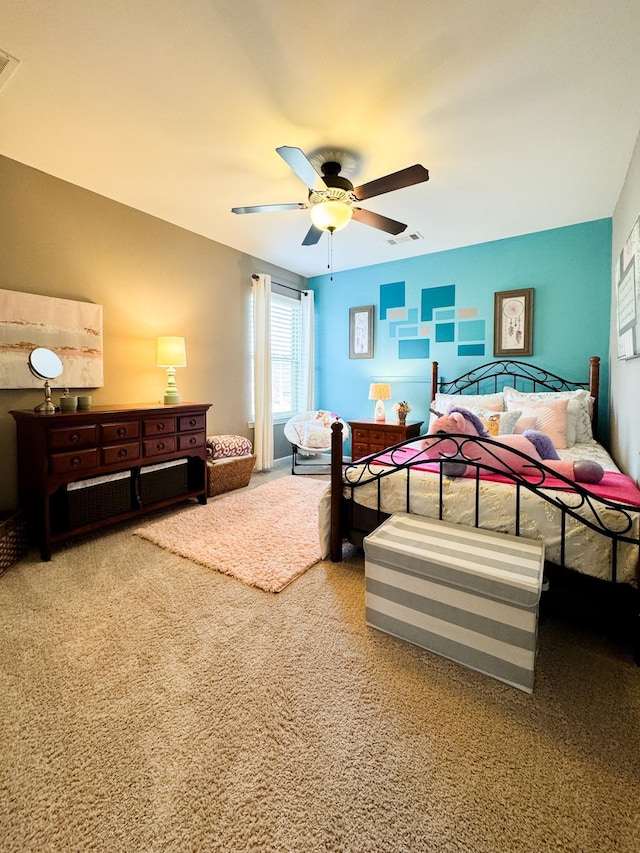 carpeted bedroom featuring visible vents and a ceiling fan