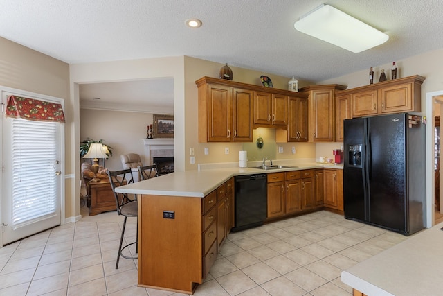 kitchen featuring brown cabinets, a peninsula, and black appliances