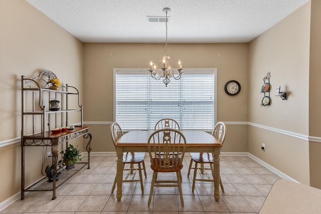 dining room with a chandelier, visible vents, a textured ceiling, and light tile patterned flooring