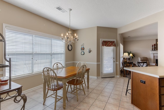 dining room featuring a textured ceiling, light tile patterned floors, visible vents, and a chandelier