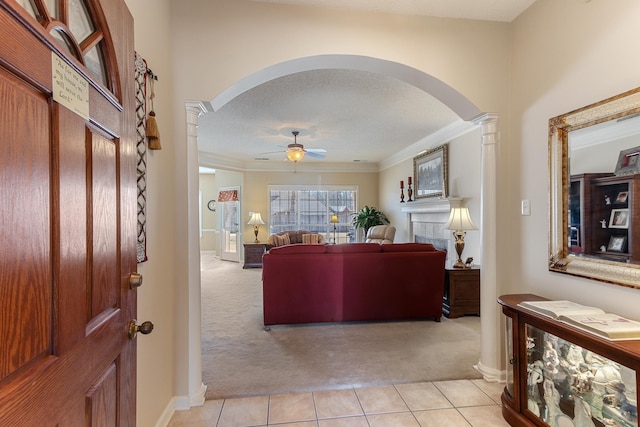 living room featuring decorative columns, arched walkways, and light carpet