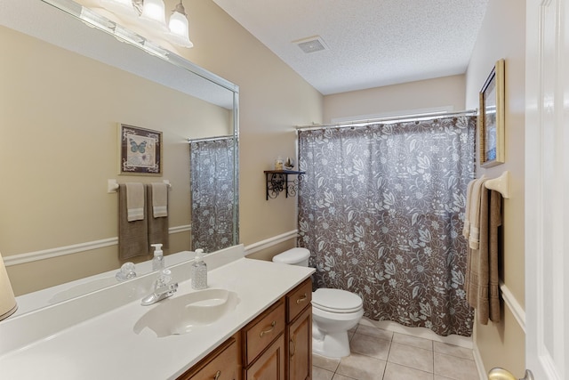 full bathroom with visible vents, toilet, vanity, tile patterned floors, and a textured ceiling