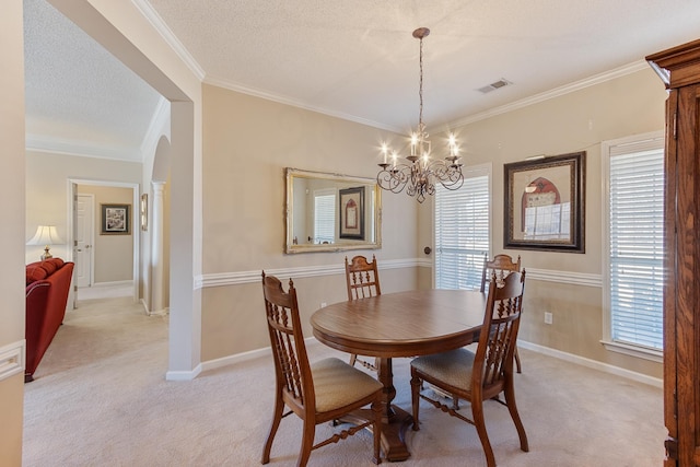 dining room with a wealth of natural light, light carpet, a chandelier, and crown molding