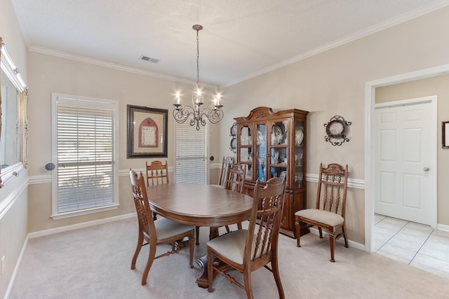 dining area with baseboards, visible vents, an inviting chandelier, ornamental molding, and light carpet