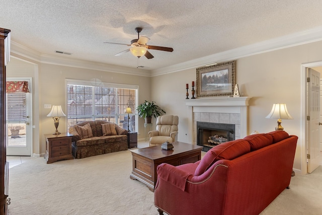 living room with visible vents, a fireplace, ceiling fan, ornamental molding, and light carpet