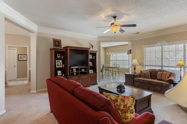 living area with visible vents, light carpet, ornamental molding, and ceiling fan with notable chandelier