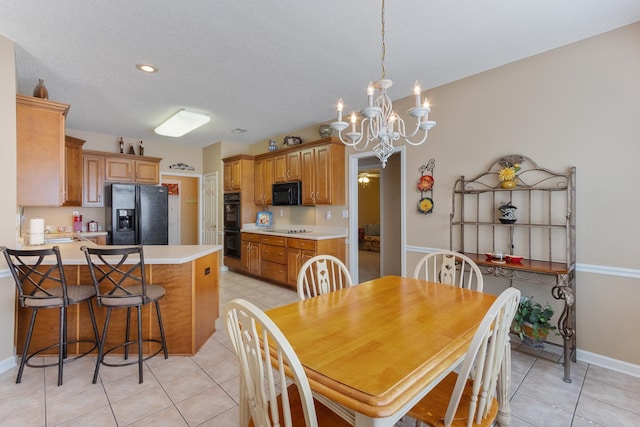 dining space with an inviting chandelier, light tile patterned floors, baseboards, and a textured ceiling