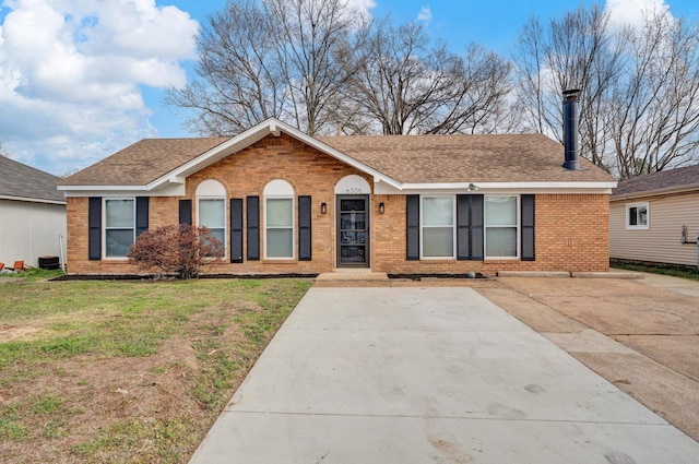 ranch-style home featuring a front yard, brick siding, and a shingled roof