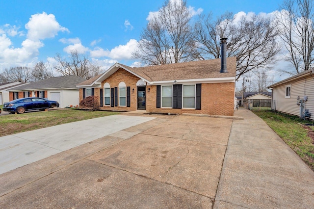 single story home featuring brick siding, fence, a front yard, and roof with shingles