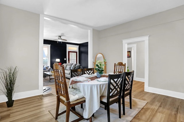 dining area with light wood-type flooring, baseboards, and a ceiling fan