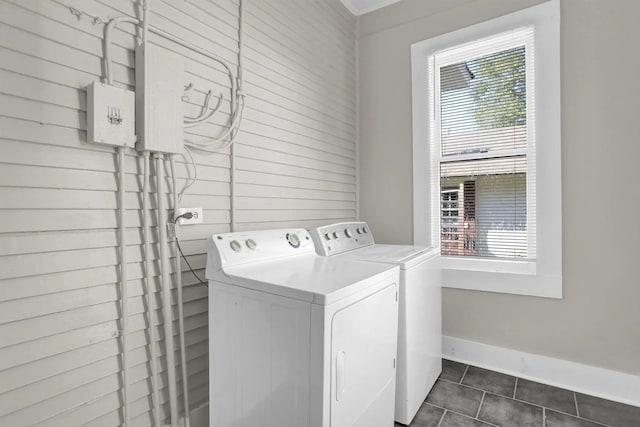 washroom featuring washer and clothes dryer, plenty of natural light, laundry area, and dark tile patterned flooring