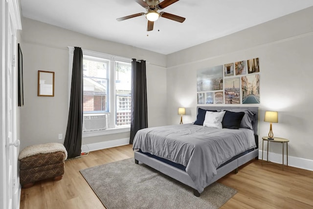 bedroom with light wood finished floors, ceiling fan, and baseboards