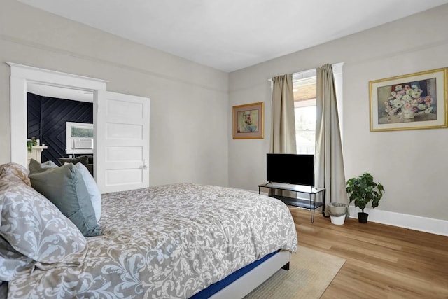 bedroom with wood finished floors and baseboards