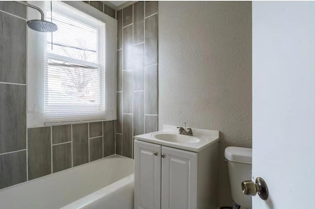 bathroom featuring toilet, a tub to relax in, a shower, vanity, and a textured wall