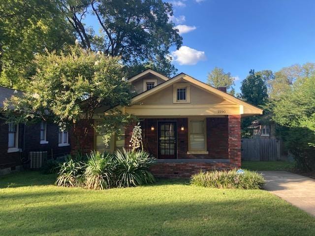 view of front of house with a porch, a front lawn, and fence