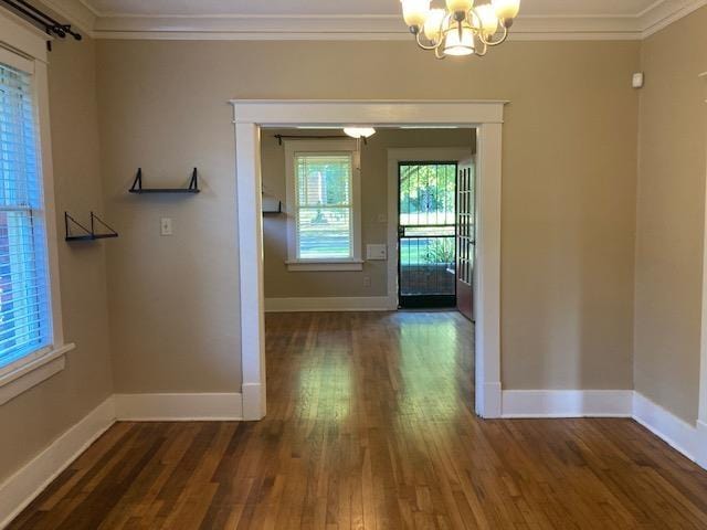 interior space featuring an inviting chandelier, baseboards, and ornamental molding