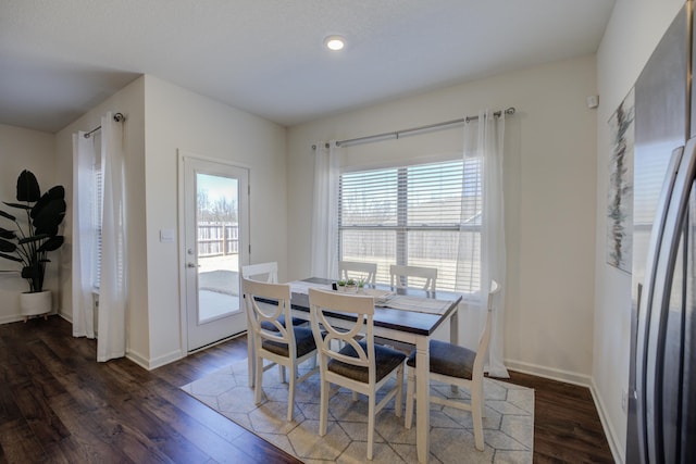 dining area with dark wood-type flooring and baseboards