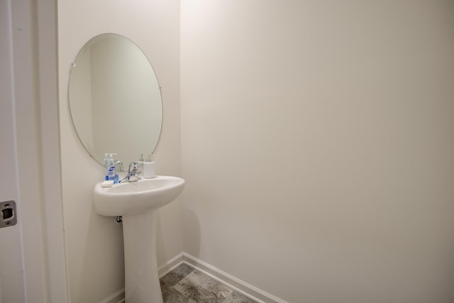 bathroom featuring a sink and baseboards