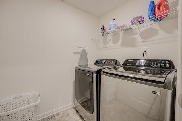 laundry area with laundry area, washer and dryer, and baseboards