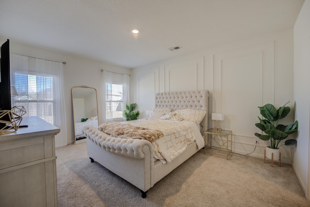 bedroom with visible vents, light colored carpet, and baseboards