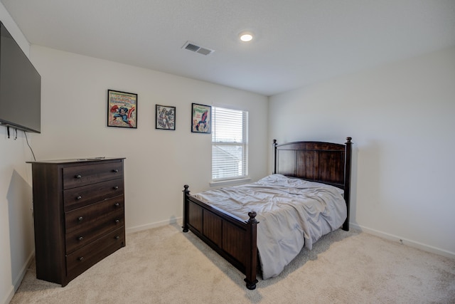 bedroom featuring visible vents, light carpet, and baseboards