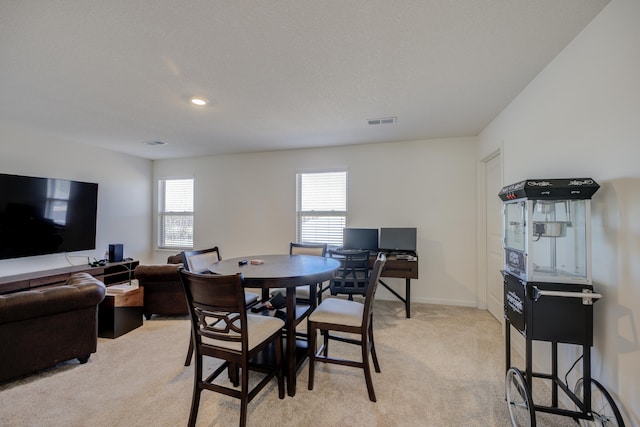 dining area with visible vents, light colored carpet, and baseboards