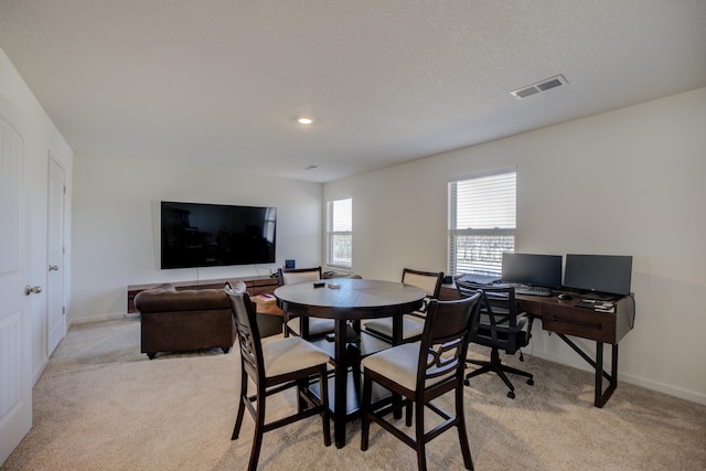 dining space featuring visible vents, light colored carpet, and baseboards