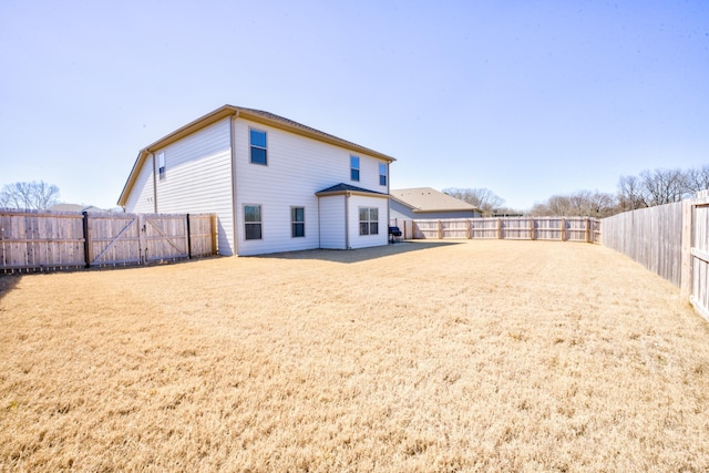 rear view of house featuring a yard, a patio, and a fenced backyard