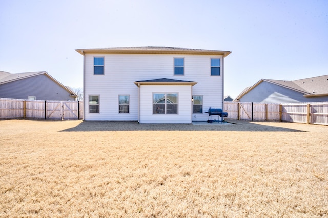 back of property with a lawn and a fenced backyard