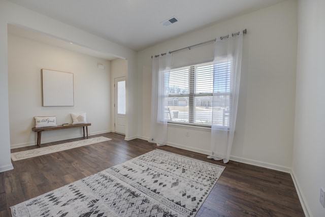 foyer featuring visible vents, baseboards, and wood finished floors