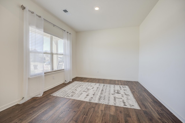 unfurnished room with recessed lighting, visible vents, baseboards, and dark wood-style floors