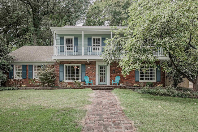 view of front of home featuring brick siding, a porch, and a front yard