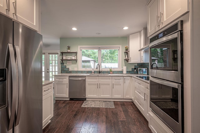 kitchen with a sink, open shelves, a healthy amount of sunlight, and stainless steel appliances