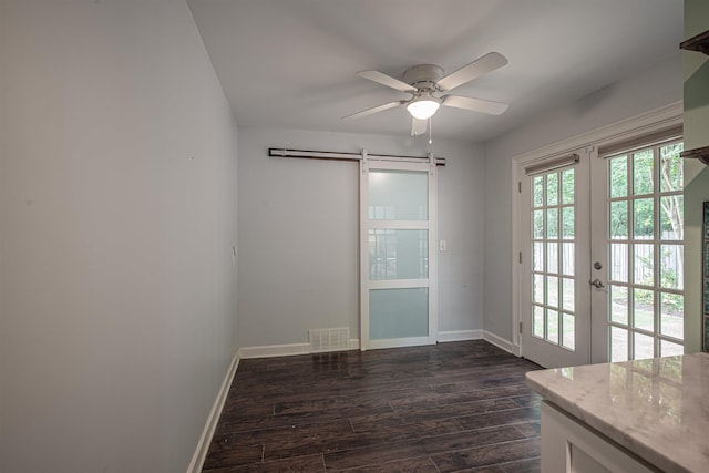 interior space featuring visible vents, dark wood finished floors, ceiling fan, french doors, and a barn door