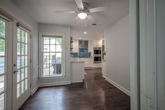 interior space featuring dark wood-style floors, visible vents, ceiling fan, and baseboards