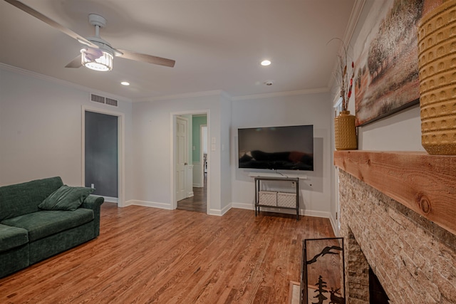 living area featuring visible vents, crown molding, baseboards, and wood finished floors