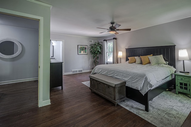 bedroom with visible vents, crown molding, baseboards, and wood finished floors