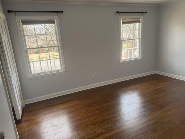 unfurnished room featuring baseboards, dark wood-style floors, and ornamental molding