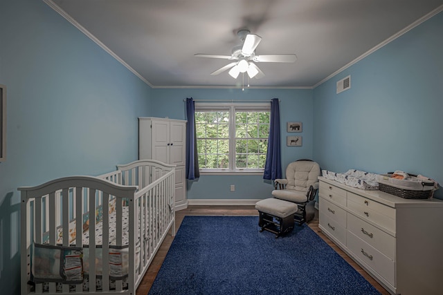 unfurnished bedroom featuring visible vents, a nursery area, dark wood-style floors, and crown molding