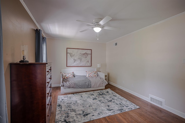 bedroom featuring wood finished floors, visible vents, and ornamental molding