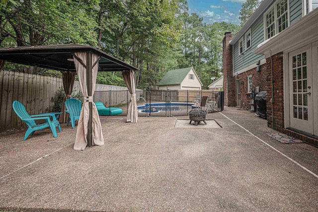 view of patio / terrace with a fenced in pool, a fenced backyard, and a fire pit