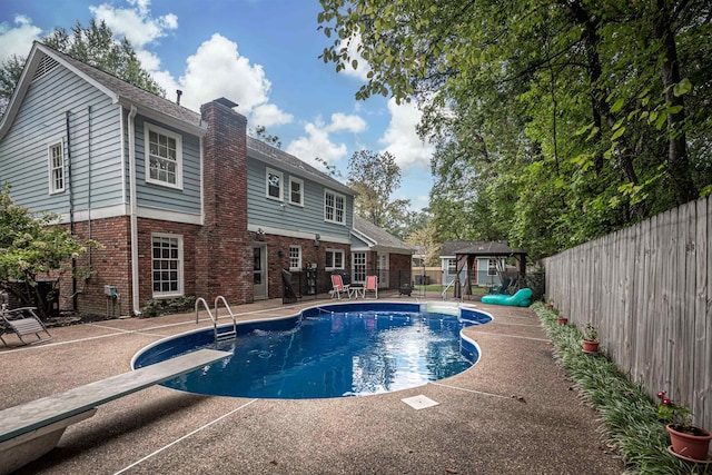 view of pool with a diving board, a fenced in pool, a patio, and a fenced backyard