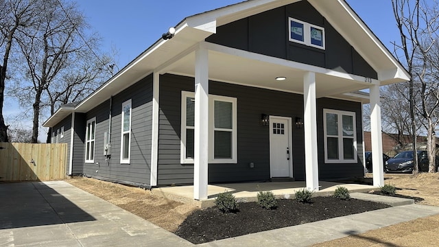 view of front of home featuring a porch and fence