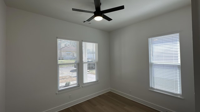 unfurnished room with dark wood-type flooring, baseboards, visible vents, and ceiling fan